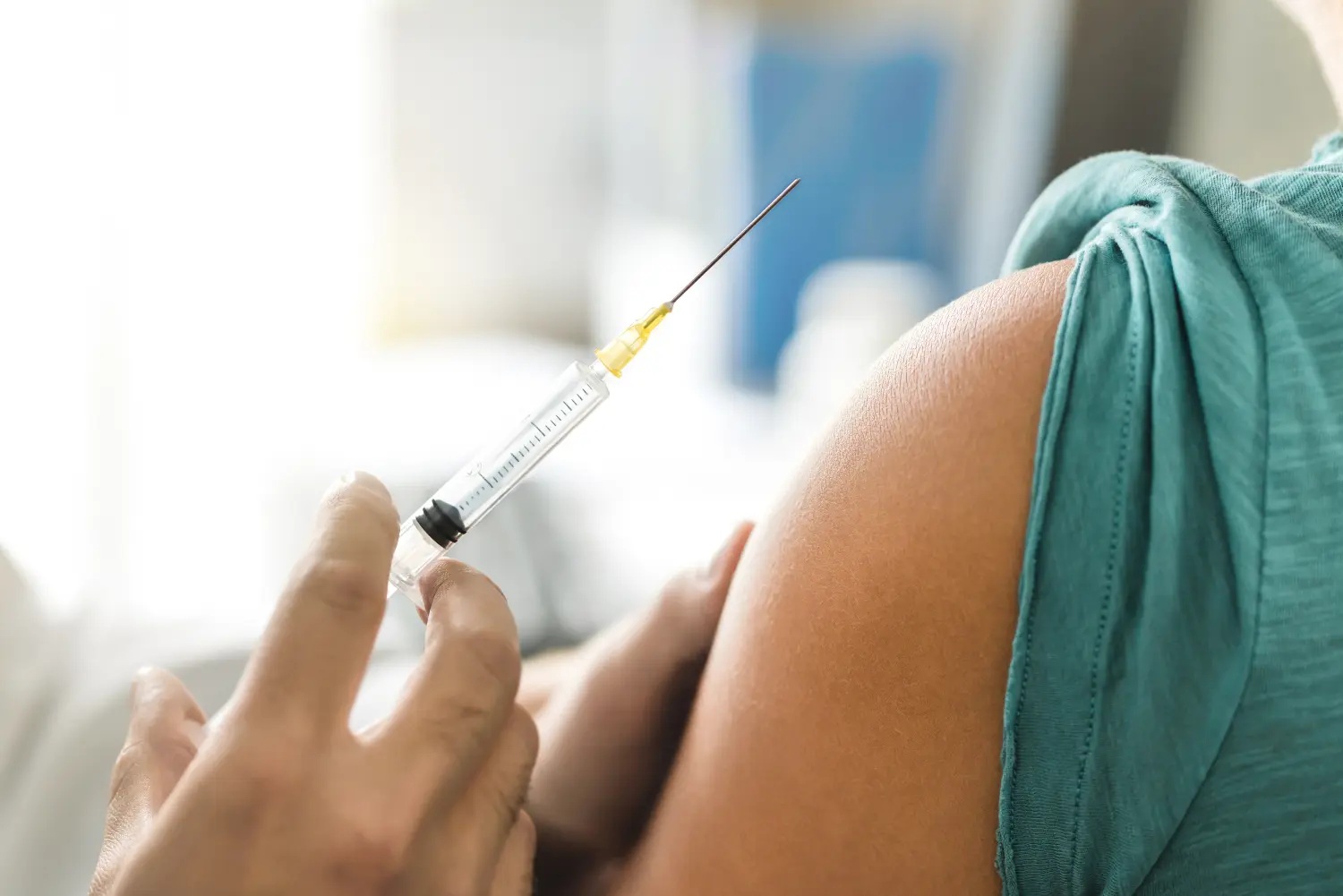 Impfstoff oder Grippeimpfung in Injektionsnadel. Arzt arbeitet mit dem Arm des Patienten